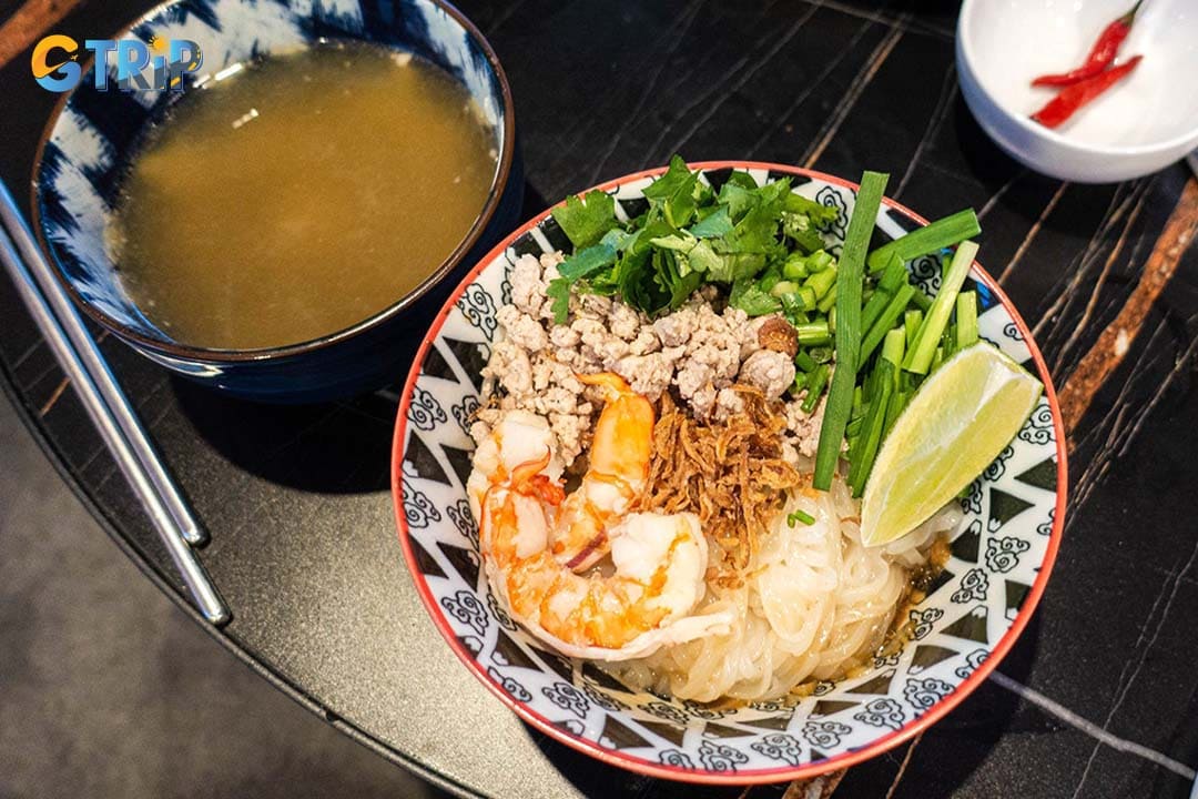 Hu tieu is the district's signature dish - a savory pork-based noodle soup, often served "dry" with the broth on the side